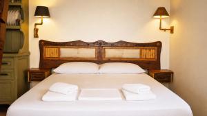 a bedroom with a bed with two towels on it at Panoramic Sea View Wooden Cottage Ratzakli, Kefalonia in Ratzaklíon