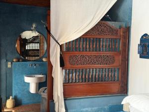 a bathroom with a large wooden door with a sink at Dar Mayssane in Rabat
