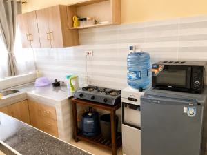 a small kitchen with a stove and a microwave at Fahari House in Embu