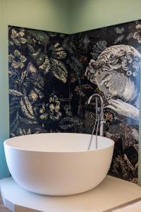 a bathroom with a white bath tub and a wall at Voko by Uka Boutique Hotel in Tirana +44 photos