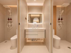 a bathroom with a sink and a toilet and a mirror at Lucky Designer Residence Near Bell Tower & City Wall in Xi'an +100 photos