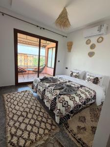 a bedroom with a large bed and a balcony at Qamar Mgouna Hotel in El Kelaa des Mgouna