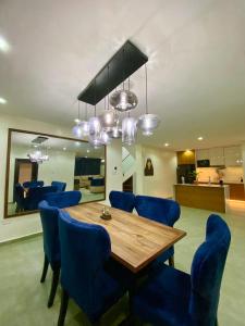 a dining room with a wooden table and blue chairs at The Crest Triplex in Ikeja