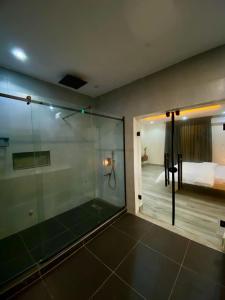 a glass shower in a room with a bedroom at The Crest Triplex in Ikeja