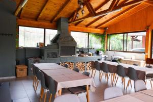 a dining room with tables and chairs and a fireplace at Prestige House Delux in Curtea de Argeş