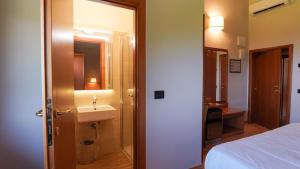 a bathroom with a sink and a bed and a mirror at Locanda La Scottiglia in Seggiano +115 photos