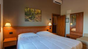 a bedroom with a large bed and two lamps at Locanda La Scottiglia in Seggiano