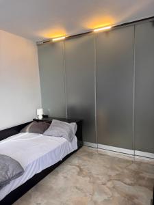 a bedroom with a large bed with a gray wall at Апартамент 310 in Primorsko