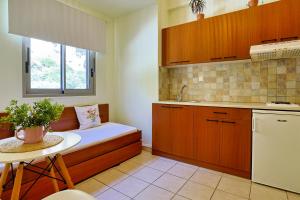 a kitchen with a bench with a table and a sink at Skinos Apartments in Plakias