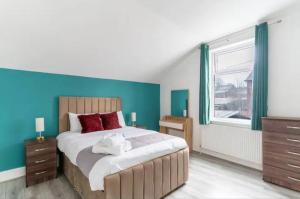 a bedroom with a large bed with a blue wall at Mauldeth Shared House in Manchester
