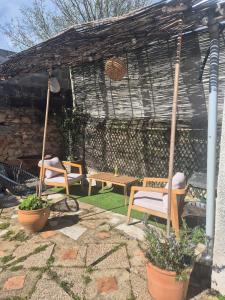 a patio with two chairs and a table at Maison en bord de rivière in Cheffes-sur-Sarthe