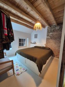 a bedroom with a large bed and a brick wall at Maison en bord de rivière in Cheffes-sur-Sarthe