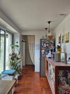 a kitchen with a refrigerator in a room at Maison en bord de rivière in Cheffes-sur-Sarthe