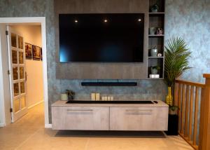 a living room with a large tv on the wall at Casa Era Canaria in Arona