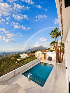 a pool on a balcony with a rainbow in the sky at Casa Era Canaria in Arona