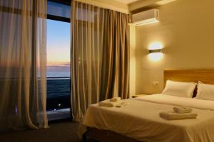 a hotel room with a bed and a large window at Hotel Zich in Kobuleti +61 photos