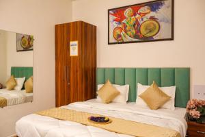 a bedroom with two beds with a green headboard at Coco House in Greater Noida