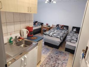 a kitchen with a sink and two beds in a room at Apartmani Konta in Livno
