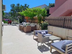 a patio with chairs and tables and a fence at Apartments Neli in Vinišće