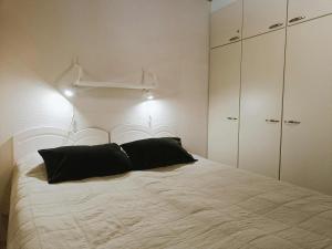 a bedroom with a large white bed with black pillows at Kärpänpesä B in Syöte
