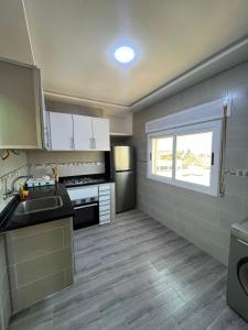 a kitchen with white cabinets and a sink and a window at costa in Oued Laou