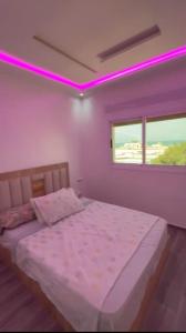 a bedroom with a large bed with purple lighting at costa in Oued Laou