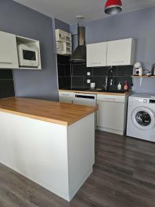 a kitchen with white cabinets and a washer and dryer at Les Trésors à 2 pas du Pal in Dompierre-sur-Besbre