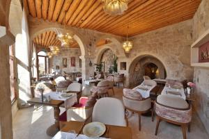 a restaurant with tables and chairs in a building at Elika Cave Suites Cappadocia, Curio Collection by Hilton in Ortahisar