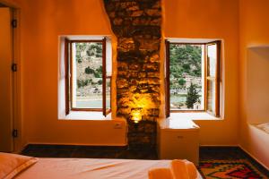a bedroom with two windows in an orange room at Stone Villa Berat in Berat +41 photos