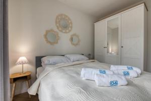 a bedroom with a white bed with towels on it at Łebska Osada- basen, parking in Żarnowska