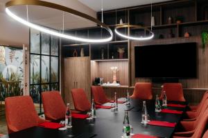 ein Konferenzraum mit einem Tisch und roten Stühlen in der Unterkunft Maison Rouge Strasbourg Hotel & Spa, Autograph Collection in Straßburg