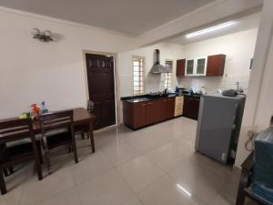 a large kitchen with a table and a refrigerator at 2bhk furnished Richmond town in Bangalore