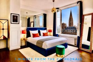 a bedroom with a blue bed and a large window at LIFE CATHEDRALE City-Center Place Gutenberg in Strasbourg