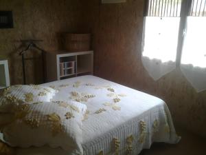 a bedroom with a bed with a white comforter at Le Chalet De Pierre Sèche in Chaumard