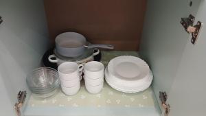 a group of white plates and a pot on a shelf at Studio Miguel in Veliko Tŭrnovo