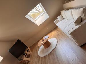 a small living room with a couch and a tv at Sous les combles in Hambach