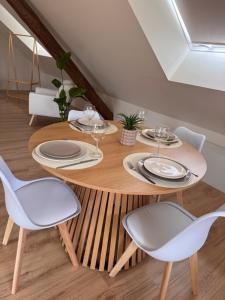 a dining room with a wooden table and chairs at Sous les combles in Hambach +1 photo