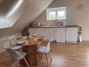a kitchen with a wooden table and chairs and a kitchen with a sink at Sous les combles in Hambach