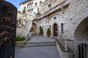 a building with stairs leading to a door with potted plants at Elika Cave Suites Cappadocia, Curio Collection by Hilton in Ortahisar
