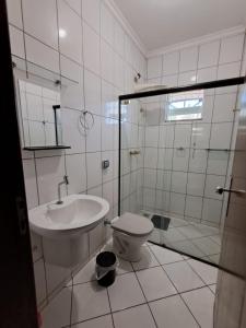a bathroom with a toilet and a sink and a shower at Apartamento São Pedro SP in São Pedro