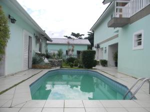 a swimming pool in the backyard of a house at Kitnets & Flats in Ubatuba