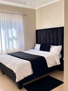a bedroom with a large bed with a black headboard at High tide complex in Langstrand