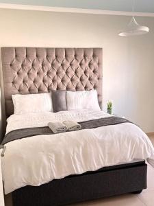 a large bed with a large headboard in a bedroom at High tide complex in Langstrand +5 photos