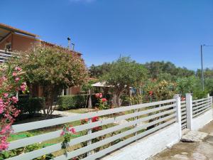 a white fence in front of a house with flowers at Spiti Lou in Nótos