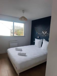 a bedroom with a large bed with two towels on it at Maison près de la plage in Sangatte