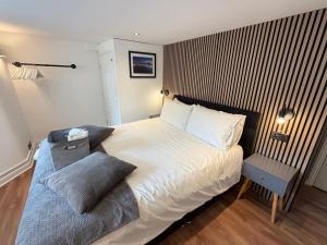 a bedroom with a large bed and a chair at Westons Hideaway, 2 Bed, Free Parking, 6 mins walk to beach, in Weston-super-Mare