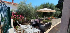 a patio with chairs and an umbrella at Marija Holiday Home in Sućuraj