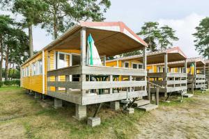 una pequeña casa amarilla con techo expuesto en Oostappen Vakantiepark Marina Beach BV, en Hoek