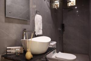 a bathroom with a tub and a toilet and a sink at Coco House in Greater Noida +23 photos