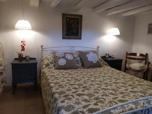 a bedroom with a bed with two tables and two lamps at Cozy stone house in Sikéa